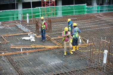 MALACCA, MALAYSIA -27 Mayıs 2016: Malezya 'daki inşaat alanında çelik takviye barı üreten inşaat işçileri. Destek çubuğu ince bir kabloyla birbirine bağlanmış..  