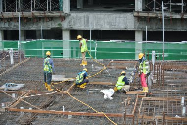 MALACCA, MALAYSIA -27 Mayıs 2016: Malezya 'daki inşaat alanında çelik takviye barı üreten inşaat işçileri. Destek çubuğu ince bir kabloyla birbirine bağlanmış..  