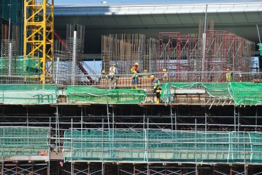 MELAKA, MALAYSIA -6 Nisan 2016: Melaka, Malezya 'daki inşaat sahasında çalışırken emniyet kemeri ve yeterli güvenlik donanımı takan inşaat işçileri.