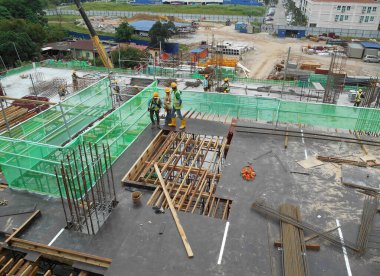 MELAKA, MALAYSIA -6 Nisan 2016: Melaka, Malezya 'daki inşaat sahasında çalışırken emniyet kemeri ve yeterli güvenlik donanımı takan inşaat işçileri.