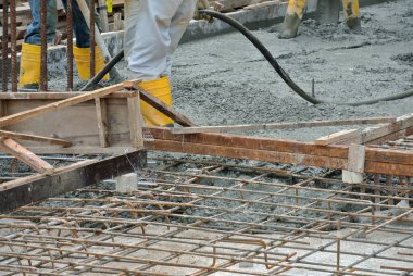 SELANGOR, MALAYSIA -18 Haziran 2016: İnşaat alanında beton vibratör kullanan inşaat işçileri, resmi çalışmanın üzerine dökülen beton çamuru sıkıştırmak için. 