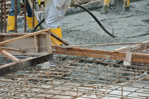 SELANGOR, MALAYSIA -18 Haziran 2016: İnşaat alanında beton vibratör kullanan inşaat işçileri, resmi çalışmanın üzerine dökülen beton çamuru sıkıştırmak için. 