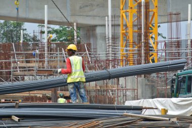 SERDANG, MALAYSIA - 26 Kasım 2016: İnşaat işçileri vinç kullanarak bir demet çelik takviyesi taşıyorlar.