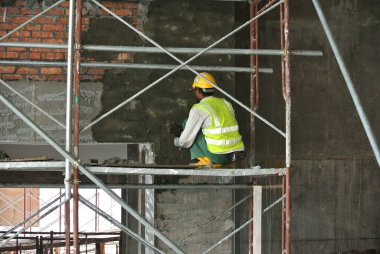 SEPANG, MALAYSIA - 20 EYLÜL 2016: Sepang, Malezya 'daki inşaat sahasında beton sıva kullanarak duvar ve kiriş yapıştıran inşaat işçileri