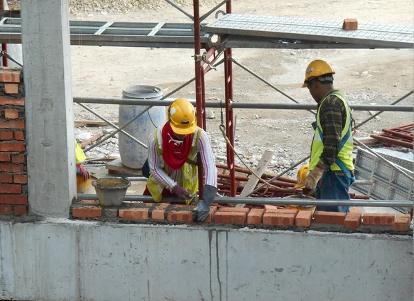 JOHOR, MALAYSIA -AĞUSTOS 05, 2016: İnşaat alanında inşaat duvarları oluşturmak için tuğla döşeyen tuğla ustası. 