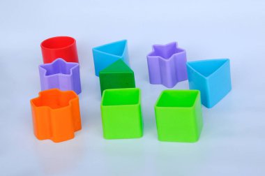 Beyaz arka planda plastikten yapılmış çeşitli şekillerde izole edilmiş çocuk oyuncak blokları. 