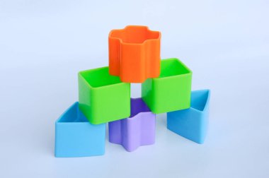 Beyaz arka planda plastikten yapılmış çeşitli şekillerde izole edilmiş çocuk oyuncak blokları. 