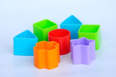 Beyaz arka planda plastikten yapılmış çeşitli şekillerde izole edilmiş çocuk oyuncak blokları. 