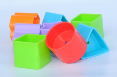 Beyaz arka planda plastikten yapılmış çeşitli şekillerde izole edilmiş çocuk oyuncak blokları. 