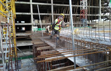 MALACCA, MALAYSIA -23 Eylül 2016: Malezya 'daki inşaat alanında çelik takviye barı üreten inşaat işçileri. Destek çubuğu ince bir kabloyla birbirine bağlanmış..  