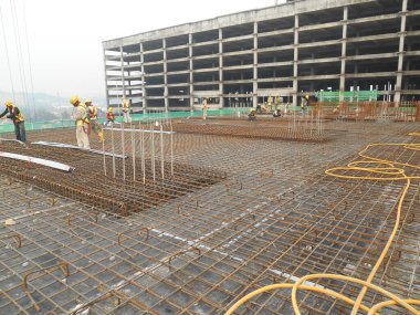 SEREMBAN, MALAYSIA -HAZİRAN 01 HAZİRAN 2016: Gündüz Malezya 'nın Seremban kentindeki şantiyede çalışan inşaat işçileri. Güvenli bir şekilde çalıştıklarından emin olmak için gerekli güvenlik ekipmanlarını giyiyorlar..  