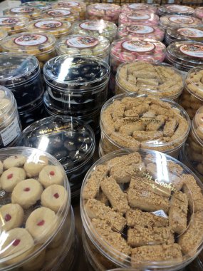 KUALA LUMPUR, MALAYSIA - 17 Mayıs 2020: Bisküviler şeffaf plastik kaplarda satılır ve tip ve fiyatlara göre sıralanır. Masada gösteriliyor. Müslümanların bayramı için özel yapım..