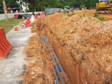 SEREMBAN, MALAYSIA -AĞUSTOS 01, 2019: İnşaat alanındaki siperlere işçiler tarafından döşenmiş yeraltı hizmet borusu. Boruların kurulumu devam ediyor.    