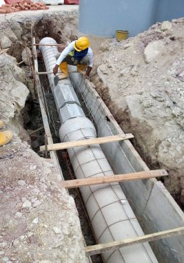 SEREMBAN, MALAYSIA -AĞUSTOS 01, 2019: İnşaat alanındaki siperlere işçiler tarafından döşenmiş yeraltı hizmet borusu. Boruların kurulumu devam ediyor.    
