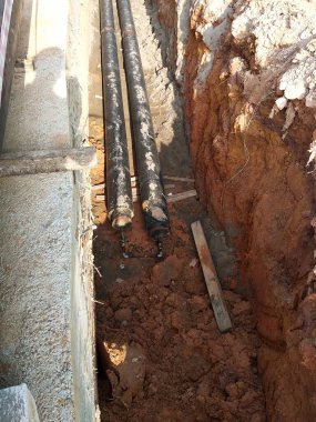 SEREMBAN, MALAYSIA -AĞUSTOS 01, 2019: İnşaat alanındaki siperlere işçiler tarafından döşenmiş yeraltı hizmet borusu. Boruların kurulumu devam ediyor.    