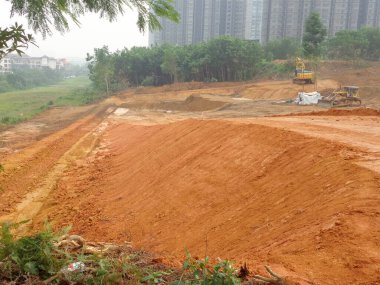 KUALA LUMPUR, MALAYSIA - 17 Temmuz 2019: İnşaat alanında toprak doldurma işi yapan ağır makineler. Bina inşaatı gerekli seviyeleri almaya başlamadan önce yapılan çalışmalar. 