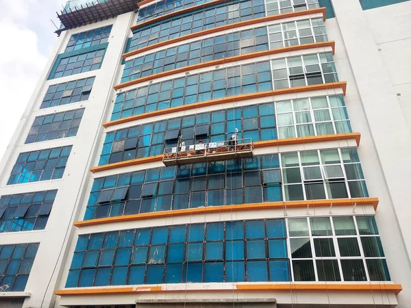 Kuala Lumpur Malaysia 2017年3月16日 作業者はサービスゴンドラを使用して建物の外部の清掃とメンテナンスを行っています 安全対策として安全ハーネスを着用しています — ストック写真