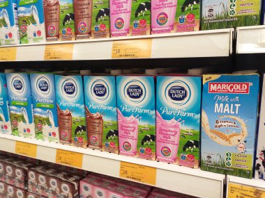 SEREMBAN, MALAYSIA - 5 Temmuz 2019: İşlenmiş ve taze süt kağıt kutuda paketlenmiş ve süpermarketlerin içindeki raflarda sergilenmektedir. Markaya göre sıralanır ve müşterinin seçmesi kolay olur.. 