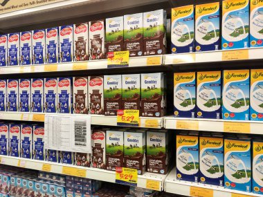 SEREMBAN, MALAYSIA - 5 Temmuz 2019: İşlenmiş ve taze süt kağıt kutuda paketlenmiş ve süpermarketlerin içindeki raflarda sergilenmektedir. Markaya göre sıralanır ve müşterinin seçmesi kolay olur.. 