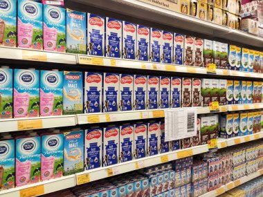 SEREMBAN, MALAYSIA - 5 Temmuz 2019: İşlenmiş ve taze süt kağıt kutuda paketlenmiş ve süpermarketlerin içindeki raflarda sergilenmektedir. Markaya göre sıralanır ve müşterinin seçmesi kolay olur.. 
