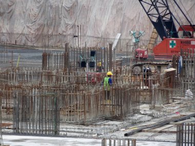 SEREMBAN, MALAYSIA - 29 Mart 2020: İnşaat işçileri inşaat alanında çelik takviye çubuğu üretiyorlar. Küçük kabloları kullanarak birbirlerine bağladılar. Bu, takviye beton yapımında atılan adımlardan biridir.. 