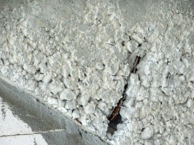 Bal peteği sorunu olan yeni beton yüzey ve içerideki takviye çubuğu açığa çıkarıyor. Sorun somut kuvveti zayıflatıyor.. 