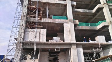 SEREMBAN, MALAYSIA - 7 Mart 2020: İnşaat alanında güçlendirilmiş çelik beton yapı inşa edilmiştir. Ahşap ve kontraplaktan yapılmış şekiller kullanılarak inşa edilmiş. İşçiler tarafından elle inşa edilmiş..