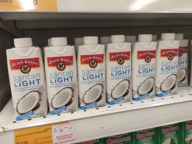 KUALA LUMPUR, MALAYSIA -4 Haziran 2020: İşlenmiş hindistan cevizi sütü küçük ticari kağıt kutuda paketlenmiş ve süpermarketin içindeki çelik bir rafta sergilenmektedir. Markaya göre sıralanır. 