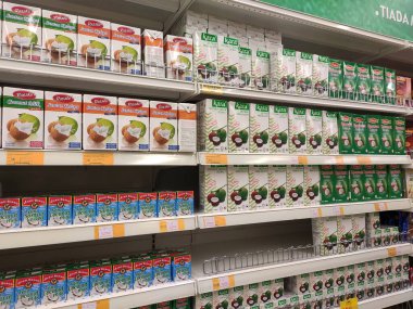 KUALA LUMPUR, MALAYSIA -4 Haziran 2020: İşlenmiş hindistan cevizi sütü küçük ticari kağıt kutuda paketlenmiş ve süpermarketin içindeki çelik bir rafta sergilenmektedir. Markaya göre sıralanır. 