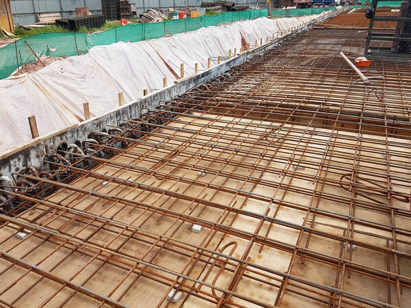 KUALA LUMPUR, MALAYSIA -MARCH 3, 2020: Building floor slab under construction. Construction workers fabricating the timber formwork and installing the steel reinforcement bar. 