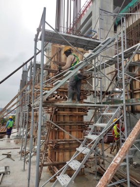 SEREMBAN, MALAYSIA -MAYIS 24, 2020: İnşaat alanında yapım aşamasında olan iskele ve metal platformdan yapılan geçici erişim ve metal merdiven. 