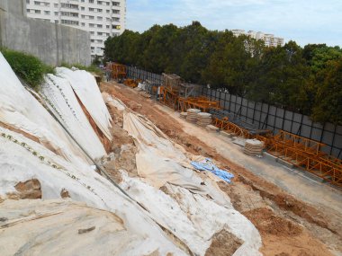 SEREMBAN, MALASIA - 3 Mart 2019: Plastik tabaka erozyonu önlemek için yamacın yüzeyine yayıldı. Ayrıca geçici olarak dengeleme işlemi bitmeden önce eğimi sabitlemek için..