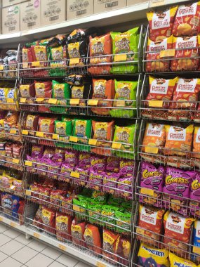 KUALA LUMPUR, MALAYSIA -APRIL 27, 2020: Markette raflarda ve satılık abur cuburlar ve paketlenmiş çeşitli abur cuburların seçici odak noktası. Her birinin kendi fiyat etiketi var.. 