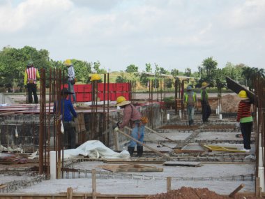 KUALA LUMPUR, MALAYSIA - 23 AĞUSTOS 2019: Gündüzleri Malezya 'daki şantiyede çalışan inşaat işçileri. Bir kazadan kaçınmak için uygun güvenlik teçhizatı giymeleri gerekiyor.. 