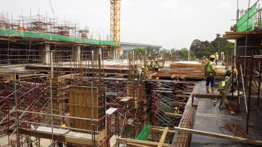 KUALA LUMPUR, MALAYSIA - 23 AĞUSTOS 2019: Gündüzleri Malezya 'daki şantiyede çalışan inşaat işçileri. Bir kazadan kaçınmak için uygun güvenlik teçhizatı giymeleri gerekiyor.. 