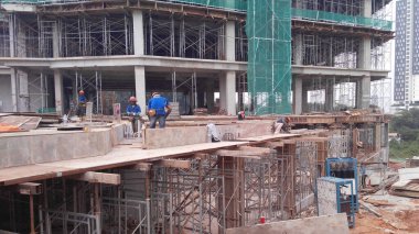 KUALA LUMPUR, MALAYSIA - 23 AĞUSTOS 2019: Gündüzleri Malezya 'daki şantiyede çalışan inşaat işçileri. Bir kazadan kaçınmak için uygun güvenlik teçhizatı giymeleri gerekiyor.. 