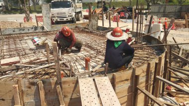 KUALA LUMPUR, MALAYSIA - 23 AĞUSTOS 2019: Gündüzleri Malezya 'daki şantiyede çalışan inşaat işçileri. Bir kazadan kaçınmak için uygun güvenlik teçhizatı giymeleri gerekiyor.. 