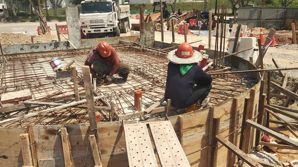 KUALA LUMPUR, MALAYSIA - 23 AĞUSTOS 2019: Gündüzleri Malezya 'daki şantiyede çalışan inşaat işçileri. Bir kazadan kaçınmak için uygun güvenlik teçhizatı giymeleri gerekiyor.. 