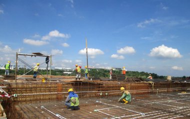 KUALA LUMPUR, MALAYSIA - 6 Haziran 2016: İnşaat şantiyesinde çalışan inşaat işçileri döşeme destek barı kuruyorlar. 