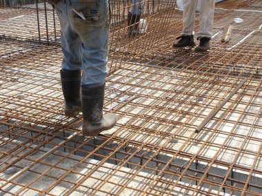 KUALA LUMPUR, MALAYSIA - 23 Eylül 2017: İnşaat işçilerinin inşaat sahasındaki zemin destekleyici barın üzerinde güvenlik ayakkabıları giymesi. 