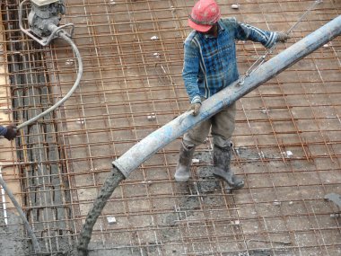 KUALA LUMPUR, MALAYSIA - 16 Haziran 2017: İnşaat işçileri inşaat sahasındaki beton pompalama makinesinin beton örümcek hortumunu kullanarak beton beton döşeyen inşaat işçileri.  