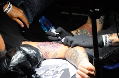 KUALA LUMPUR, MALAYSIA - 29 Mayıs 2016: Bir adam müşterilerinin ellerine dövme çiziyor.