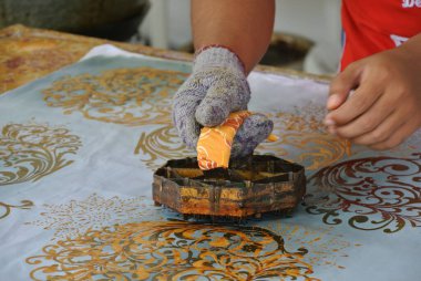 KUALA LUMPUR, MALAYSIA - 25 HAZİRAN 2016: El yapımı damga batik. Sanatçı tuşu batik tekap ya da pul batik kalıbını kullanarak batik deseni alır. 
