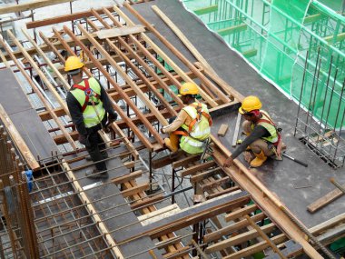 KUALA LUMPUR, MALAYSIA - Mart 05, 2020: İnşaat işçilerinin inşaat sahasına kereste döşemesi ve üretimi. Kereste ve kontraplaktan yapılan şekiller.. 