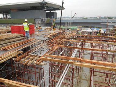 KUALA LUMPUR, MALAYSIA - Mart 05, 2020: İnşaat işçilerinin inşaat sahasına kereste döşemesi ve üretimi. Kereste ve kontraplaktan yapılan şekiller.. 