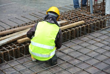 MALACCA, MALAYSIA -27 Mayıs 2016: Malezya 'daki inşaat alanında çelik takviye barı üreten inşaat işçileri. Destek çubuğu ince kabloyla birbirine bağlıydı..  