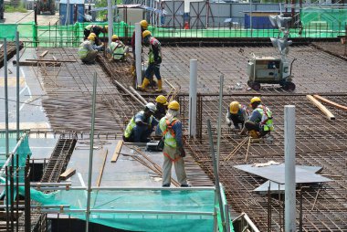 MALACCA, MALAYSIA -27 Mayıs 2016: Malezya 'daki inşaat alanında çelik takviye barı üreten inşaat işçileri. Destek çubuğu ince kabloyla birbirine bağlıydı..  