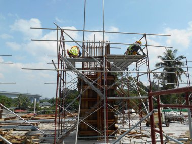 MALACCA, MALAYSIA -18 Haziran 2016: Malacca, Malezya 'daki inşaat alanında sütun kerestesi üreten inşaat işçileri. 