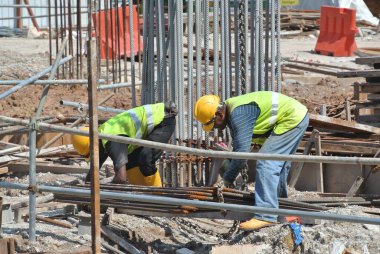 MELAKA, MALAYSIA -6 Nisan 2016: Melaka, Malezya 'daki inşaat sahasında çalışırken emniyet kemeri ve yeterli güvenlik donanımı takan inşaat işçileri.