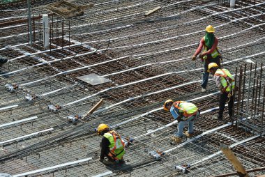 MALACCA, MALAYSIA -27 Mayıs 2016: Malezya 'daki inşaat alanında çelik takviye barı üreten inşaat işçileri. Destek çubuğu ince bir kabloyla birbirine bağlanmış..  